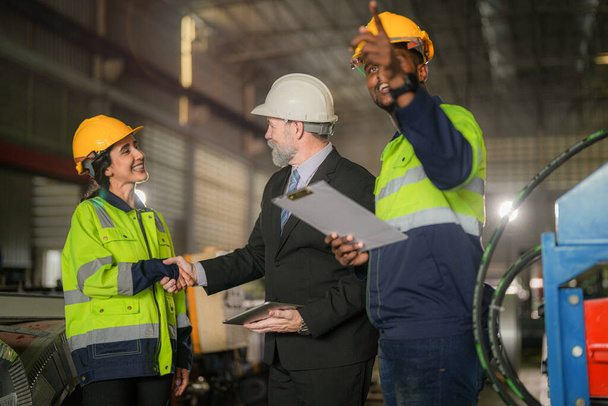 team of engineers checking control heavy machine in factory. Senior boss manager inspecting with staff engineers woman and African man. Concept Engineer Operating and control in Factory with safety. - Foto, imagen