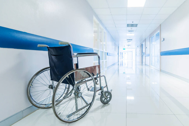 Blue tone of empty wheelchair on hospital or clinic corridor or hallway with light tunnel.Bright clean with blur background.Wheel chair in orthopedic unit for patient.Medical or insurance concept. - Φωτογραφία, εικόνα