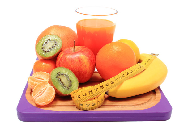 Frutas frescas, fita métrica e copo de suco
 - Foto, Imagem