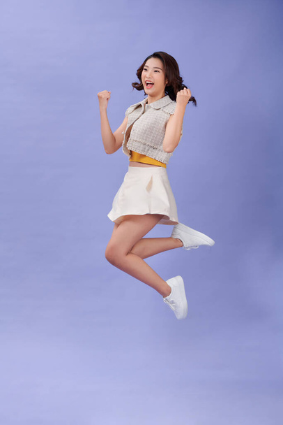 Full-body portrait of happy young student girl  jumping - Valokuva, kuva