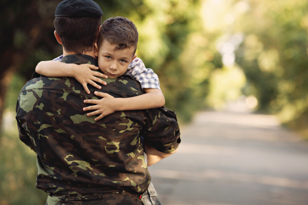 Boy and soldier in a military uniform - Foto, afbeelding