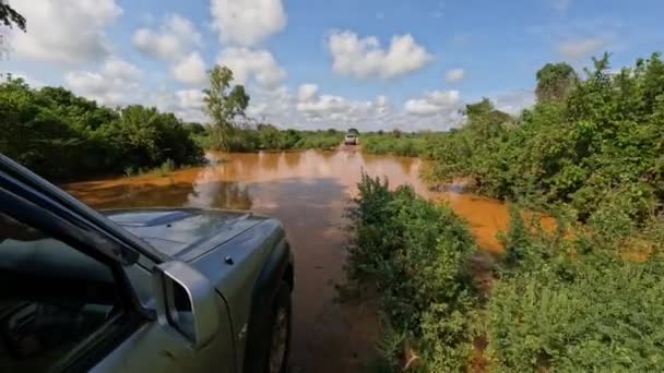 Nahaufnahme eines Reifens an einem Geländewagen, der durch die schlammige Straße von Tsingy de Bemaraha nach Morondava in Madagaskar fährt. Geländewagen nach Regen auf dem Land unterwegs - Filmmaterial, Video
