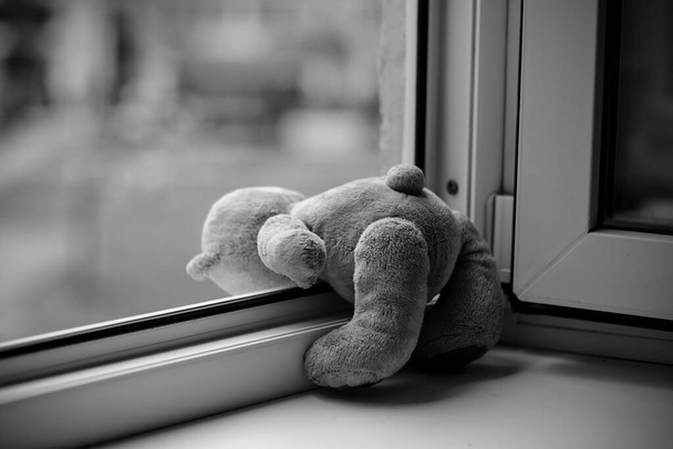 Children toy teddy bear edge open window.Concept of accidents with children - Photo, Image