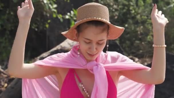 Dziewczyna w różowym poreo i kapeluszu tańczy. Wysokiej jakości materiał 4k - Materiał filmowy, wideo