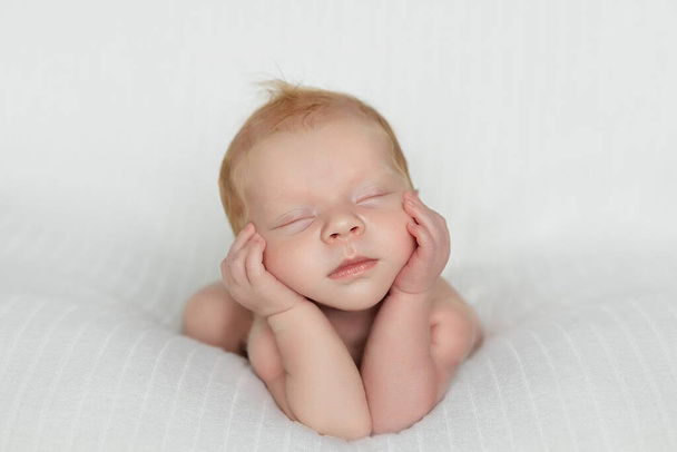 Сплячий новонароджений хлопчик у перші дні життя на білому тлі. Дитина спить на руках. Зображення крупним планом. Копіювати простір
. - Фото, зображення
