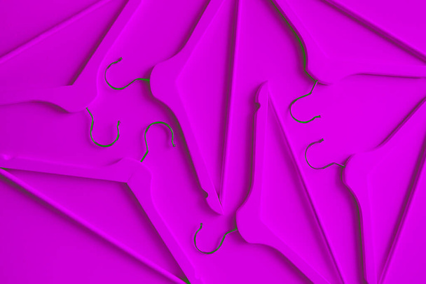 Neon wooden clothes hangers on a purple background. Sale and shopping concept. Modern fashion. - Φωτογραφία, εικόνα