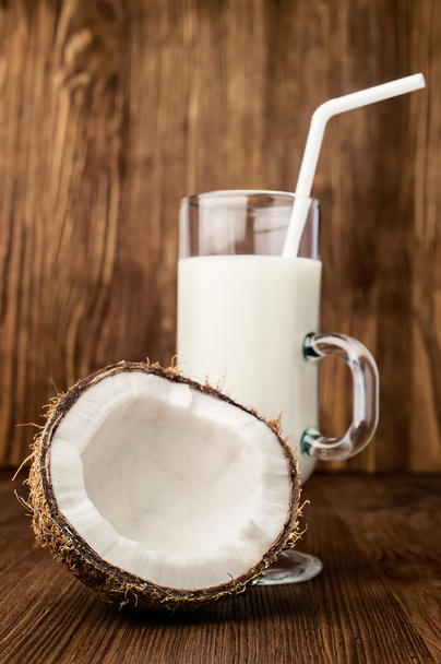 half of fresh coconut and coconut milk in a glass  - Foto, immagini
