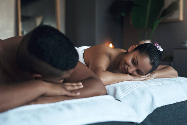 Enlever leur lune de miel avec un massage relaxant. un jeune couple se relaxant sur des lits de massage dans un spa - Photo, image