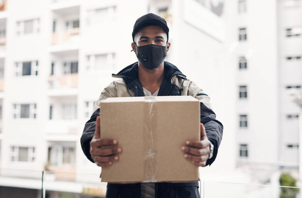 Müşterilerimizin hak ettiği ilgiyi görüyor. Maskeli genç bir adam bir eve paket getiriyor. - Fotoğraf, Görsel