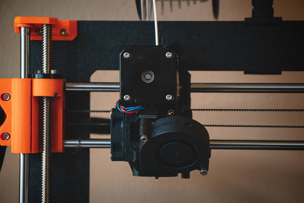 Technologiczne hi-teg narzędzie do tworzenia nowych rzeczy. Czarno-czerwona drukarka 3D w pracy. Obiekt jest tworzony poprzez układanie ciągłych warstw materiału w procesach addytywnych.. - Zdjęcie, obraz