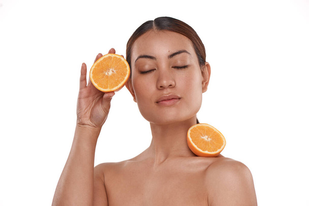Будьте в курсі продуктів, які ви оберете. красива молода жінка позує з навпіл апельсинами на її шкіру
 - Фото, зображення