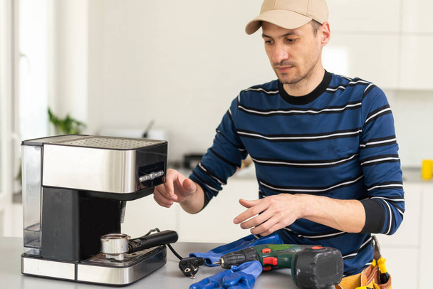 professional young worker fixing coffee machine. - Zdjęcie, obraz
