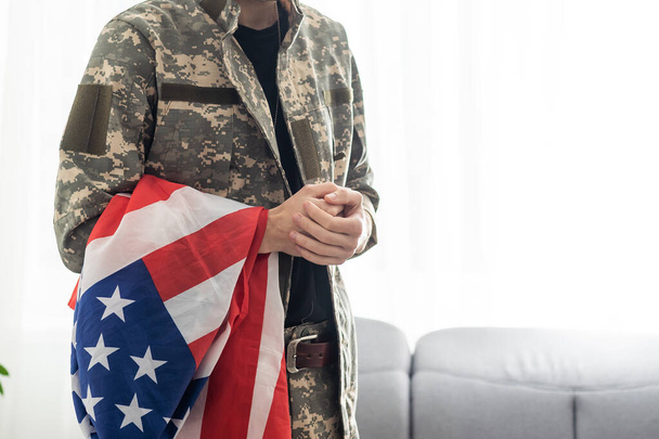 järkyttynyt amerikkalainen sotilas tilalla lippu Yhdysvaltojen itkiessään muistopäivän aikana. - Valokuva, kuva