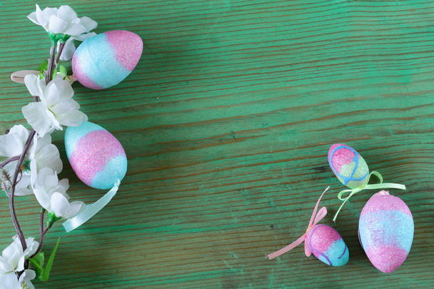 Ovos de páscoa decorativos coloridos e galho com flores de primavera no fundo de madeira velho
 - Foto, Imagem