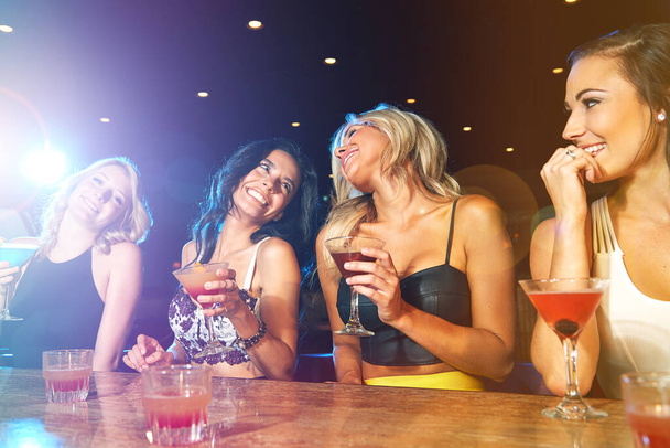 Dovremmo farlo più spesso. giovani donne che bevono cocktail in un nightclub - Foto, immagini
