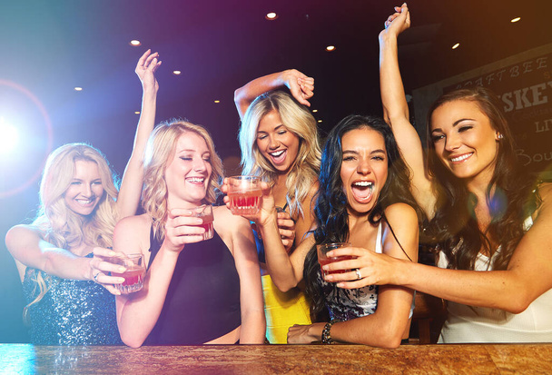 Partying hard. young women drinking cocktails in a nightclub - 写真・画像