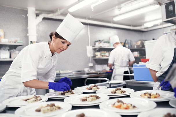 Bringing all the elements together. a chef plating food for a meal service in a professional kitchen - Фото, зображення