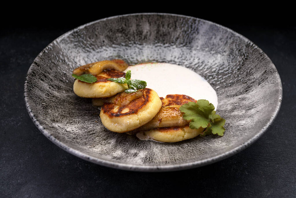 Scrumptious banana and cheese fritters with sour cream and mint - Foto, Imagem