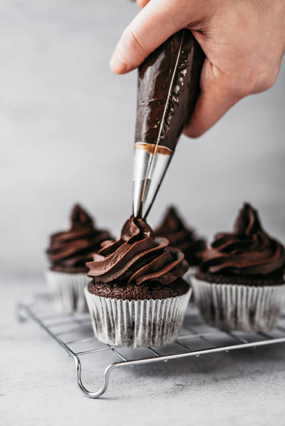 Making and decorating of delicious homemade chocolate cupcakes. Sweet food concept. - Foto, immagini