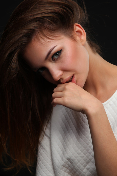 Portrait of beautiful young woman face. Isolated on dark background - Photo, image