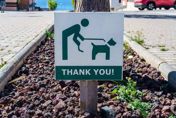 Підпишіть на дорозі інформування про зобов'язання підібрати екскременти собак. Концепція містобудування та хороші манери
 - Фото, зображення