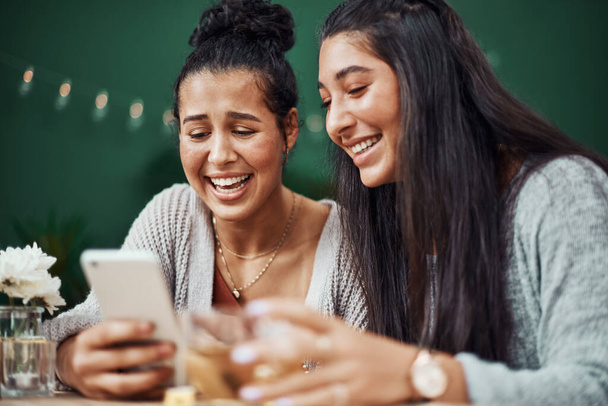 ¿Puedes creer que envió esto? hermanas jóvenes usando un smartphone juntas en un café - Foto, imagen