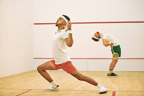 O aquecimento prepara-o física e mentalmente para o jogo. dois jovens se alongando antes de jogar um jogo de squash - Foto, Imagem