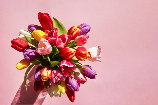 Colorful tulips bouquet on a pink background. Greeting card. Top view with copy space. Mothers day concept. - Fotó, kép