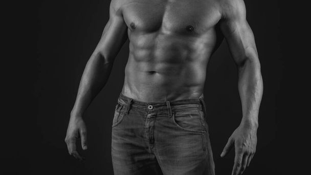 Muscle strong man guy in jeans on gray isolated background. Ideal fit body. Fashion portrait of strong brutal guy. Muscular sexy man with torso - Фото, изображение