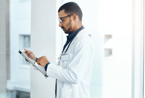 La tecnología moderna hace que la atención al paciente sea mucho más fácil. un médico joven usando una tableta digital en un hospital moderno - Foto, imagen
