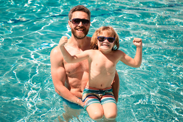 Father and son swimming in pool, summer family vacation. Pool party. Child with dad playing in swimming pool. Active weekend - Foto, Imagen