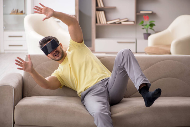 Joven estudiante masculino disfrutando de gafas virtuales en casa - Foto, imagen