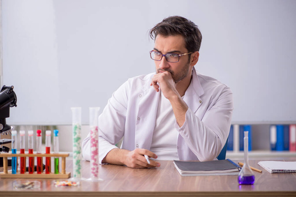 Young chemist in front of white board - Foto, afbeelding