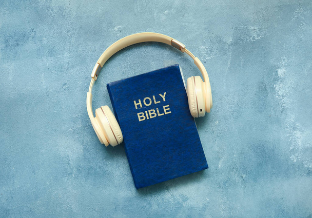 Holy Bible with headphones on blue background - Valokuva, kuva