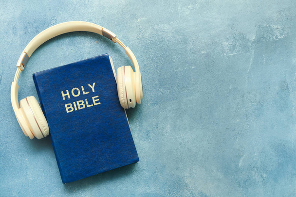 Święta Biblia ze słuchawkami na niebieskim tle - Zdjęcie, obraz