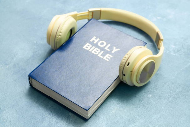Holy Bible with headphones on blue background - Fotografie, Obrázek