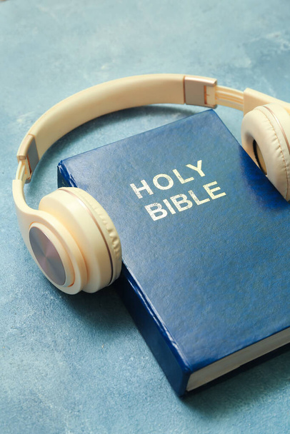 Holy Bible with headphones on blue background - Foto, imagen