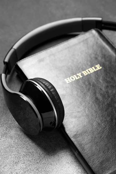 Holy Bible with headphones on grunge background, closeup - Photo, Image