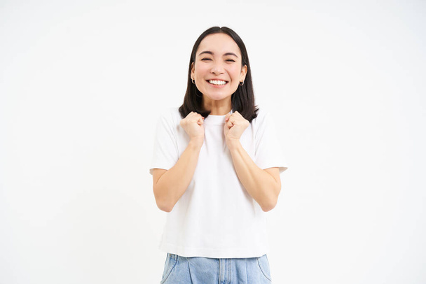 Izgalmas, szuper boldog ázsiai nő ugrás örömtől, álló felett fehér háttér. - Fotó, kép