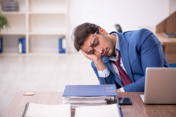 Jeune homme d'affaires employé mécontent du travail excessif sur le lieu de travail - Photo, image