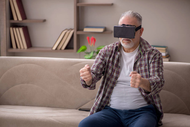 Old man enjoying virtual glasses at home - Foto, imagen