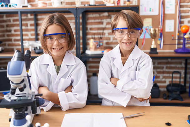 Adoráveis meninos estudantes de pé com braços cruzados gesto em sala de aula de laboratório - Foto, Imagem