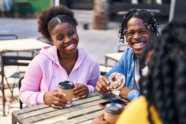 African american friends having breakfast sitting on table at coffee shop terrace - 写真・画像