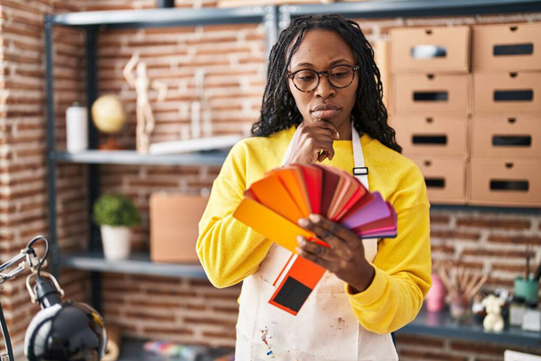 Африканская американка выбирает цвет краски в художественной студии - Фото, изображение
