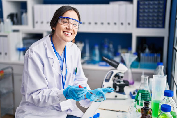 Young woman scientist analysing blood at laboratory - Φωτογραφία, εικόνα