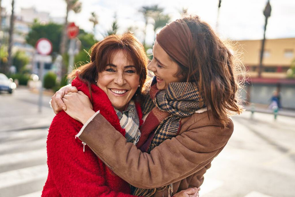 Two women mother and daughter hugging each other at street - Photo, image