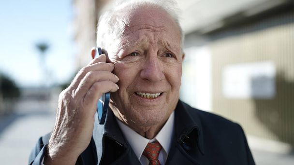 senior parlant au téléphone dans la rue - Photo, image