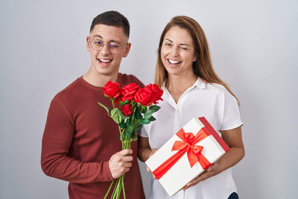 Matka a syn drží matky den dárek mrkání na kameru se sexy výraz, veselý a šťastný obličej.  - Fotografie, Obrázek