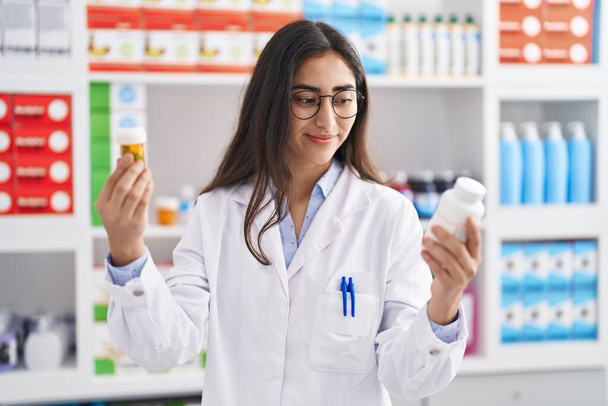 Nuori latino tyttö farmasian valitsemalla pillereitä apteekissa - Valokuva, kuva