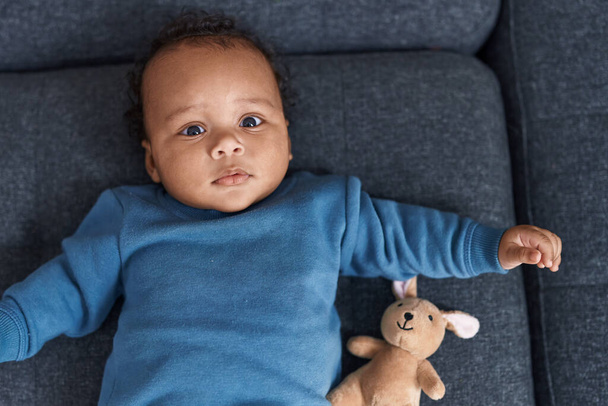 Bebé afroamericano relajándose en el sofá en casa - Foto, imagen